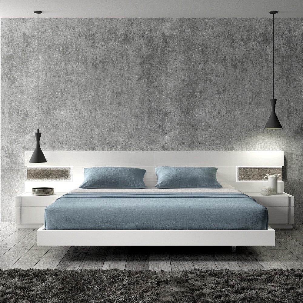 Modern white platform bed with blue bedding, floating nightstands, and pendant lights against a textured gray wall