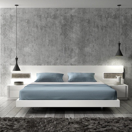 Modern white platform bed with blue bedding, floating nightstands, and pendant lights against a textured gray wall
