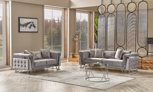 Gray sofa and armchair set in a bright, modern living room with large windows and decorative accents.