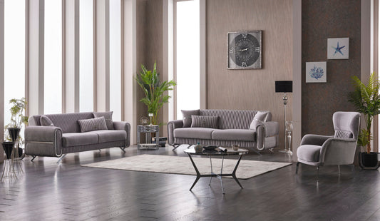 Modern gray sofa set in a bright living room with large windows, abstract wall art, and a black coffee table.